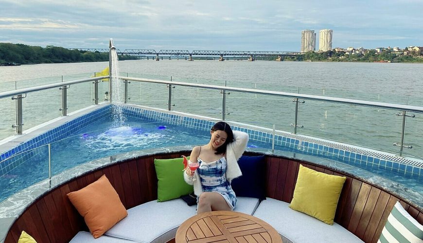 A female passenger enjoys a cup of drink on the Jade of River cruise amid the Red River in Hanoi, April 2022. Photo by VnExpress/Lan Huong