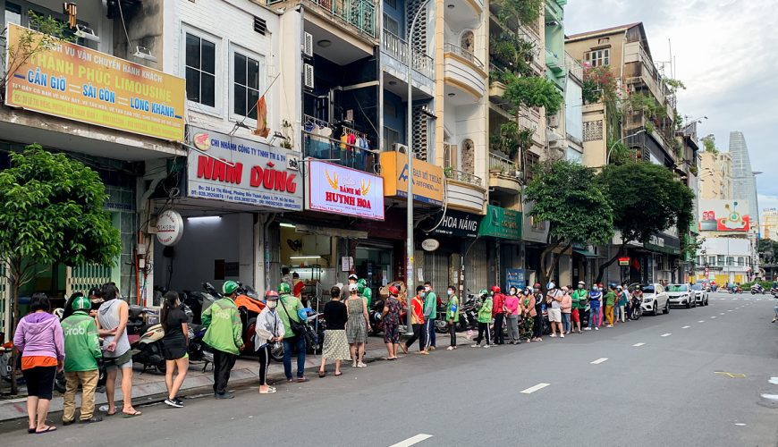 A long line of customers and shippers wait their turn in front of the Huynh Hoa stall on Le Thi Rieng Street in District 1, which has been operating for over 30 years. Nguyen Quang Huy, 37, the owner, said the shop has been as crowded as before the pandemic since the city eased social distancing measures.